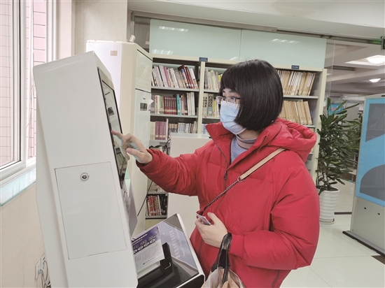 柯景如使用自助借還機自助還書。