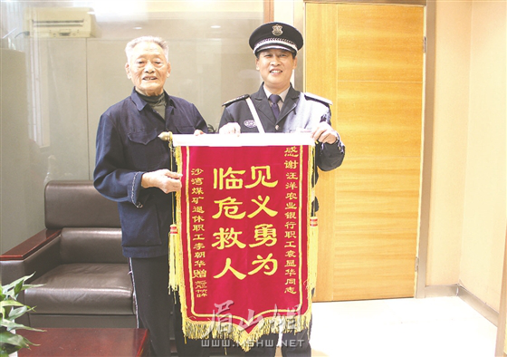 被救老人向袁顯華送見(jiàn)義勇為錦旗。.png