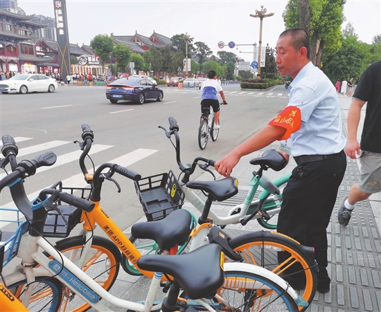 杜曾壯挪動亂停放的共享單車。.jpg